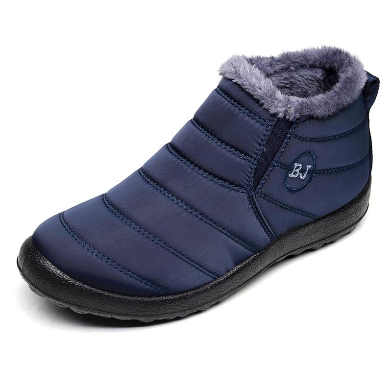 Detail of the waterproof material and stitching on a men's outdoor winter boot, ensuring warmth and protection from snow.