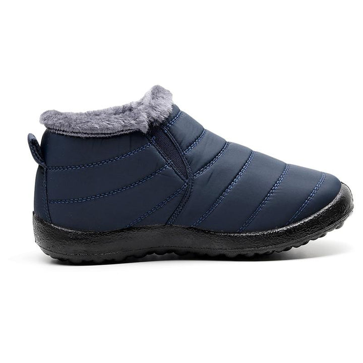 Close-up of the sole of a men's winter boot, showcasing its deep treads for superior grip on snow and ice. Rubber sole.