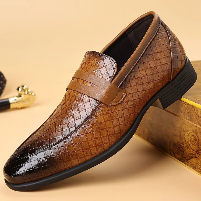 Close-up of men's black woven leather loafers, highlighting intricate texture and craftsmanship.