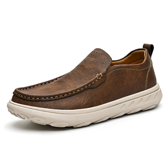 Detailed shot of the stitching on a men's brown leather slip-on loafer, quality craftsmanship.
