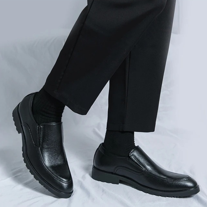Brown men's casual slip-on loafers styled with chinos, demonstrating versatile everyday footwear.