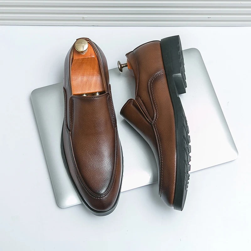White background shot of men's brown slip-on loafers, highlighting their casual comfort and style.