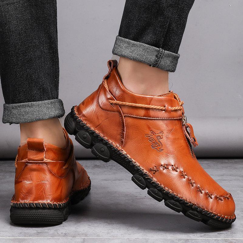 Detail shot of the hand-stitched construction on men's leather ankle boots, durable men's shoes.