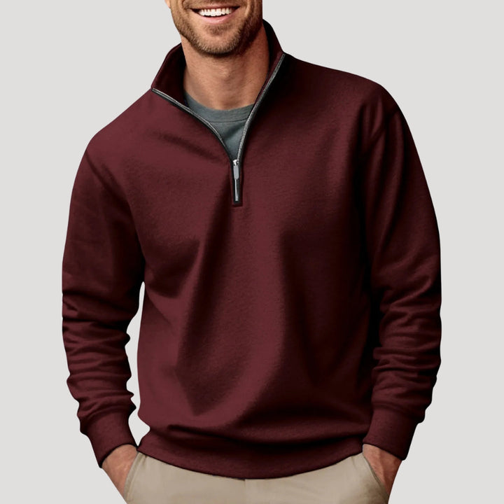 Detail of the ribbed cuffs and hem on a men's green quarter-zip pullover sweatshirt