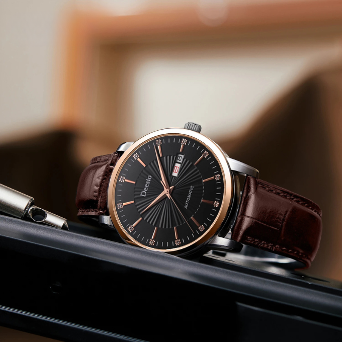 Close-up of a men's classic leather strap automatic watch, showing intricate dial details