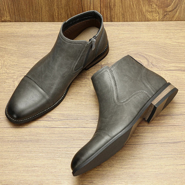 Close-up of the side-zip detail on a pair of men's classic brown Chelsea boots, versatile and stylish.