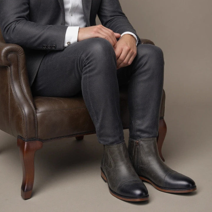 Men's classic black Chelsea boots with a cap toe and side-zip, combining traditional and modern features.