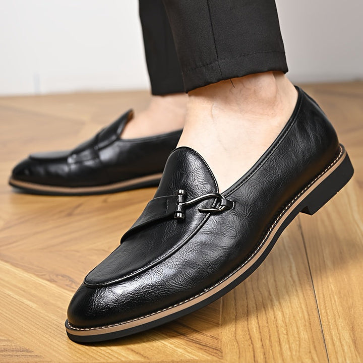 Close-up of a men's classic black leather loafer, highlighting the fine craftsmanship and texture