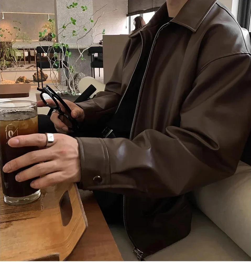 Close-up of the textured faux leather on a men's classic bomber jacket in brown