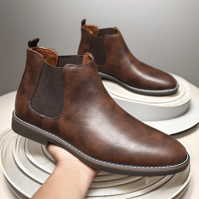 Men's dress Chelsea boots in black leather, worn with stylish casual outfit.