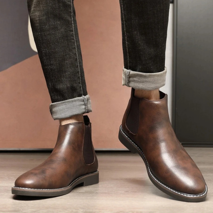 Back view of men's classic brown leather Chelsea boots, showing heel and sole.
