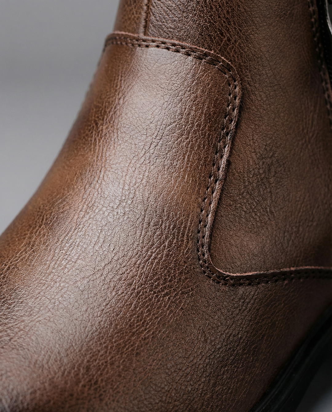 Elegant men's brown Chelsea boots on white background, highlighting craftsmanship and timeless style