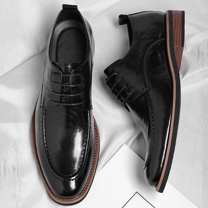 Side view of men's luxury brown Oxford dress shoes, featuring sleek lines & high-quality construction.