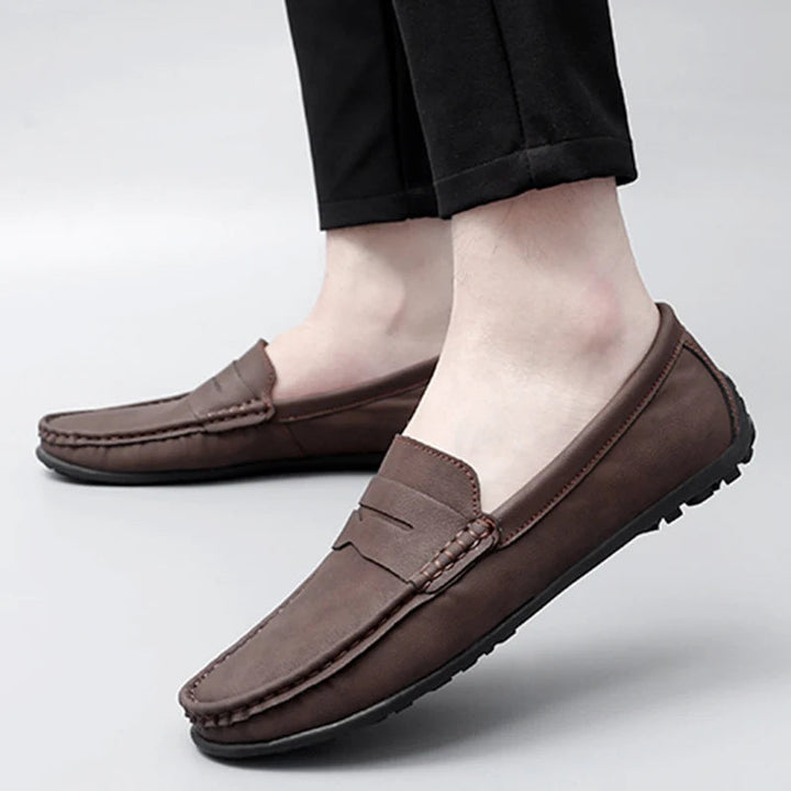 Ankle-level shot of men's leather penny loafers, showing their fit and style.