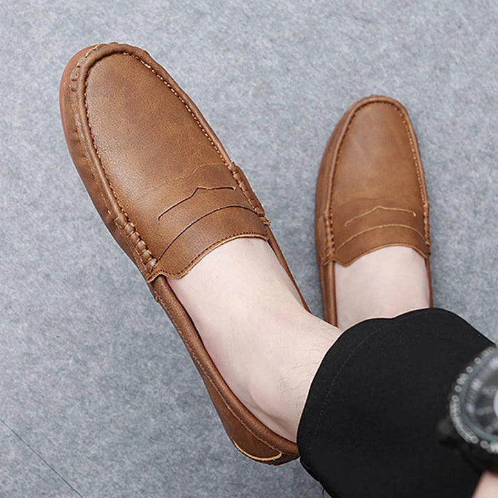Pair of men's dark brown leather penny loafers, ideal for professional attire.