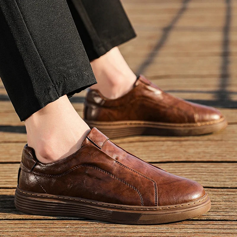 Close-up of the textured brown leather on men's slip-on casual shoes, comfortable and durable footwear.