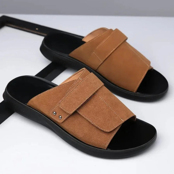 Pair of black suede men's slip-on comfort slides, ideal for everyday casual footwear.