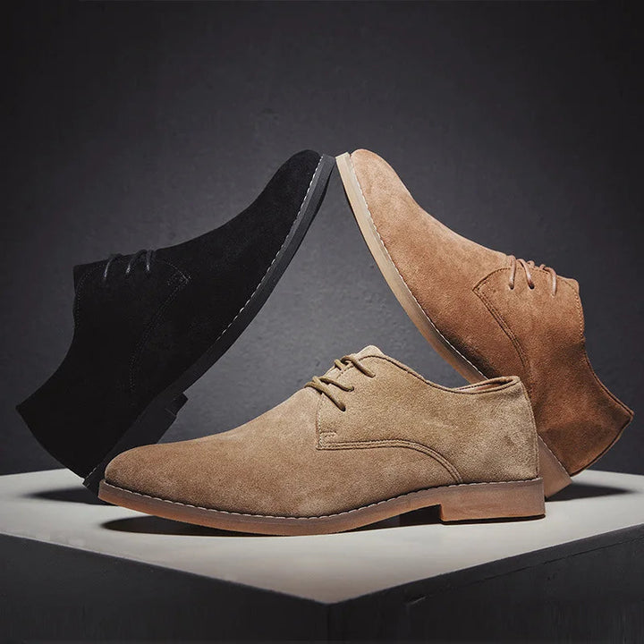 Men's elegant grey suede Oxford shoes paired with trousers, showcasing smart and comfortable style.