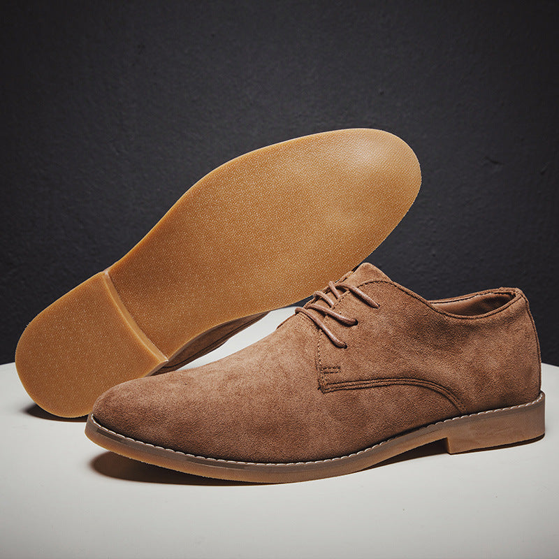 Close-up of the rich texture on a pair of men's dark blue suede Oxford shoes with laces.
