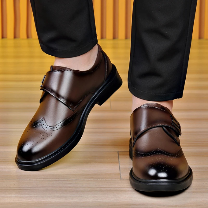 Men's classic brown leather dress shoes on a wooden floor, embodying gentleman's elegance