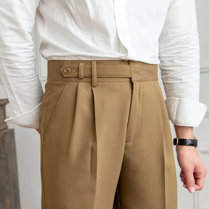 Stack of folded men's straight leg dress pants in various colors: black, navy, charcoal, light grey