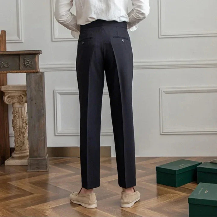 Flat lay of men's straight leg dress pants with accessories: tie, watch, and dress shoes