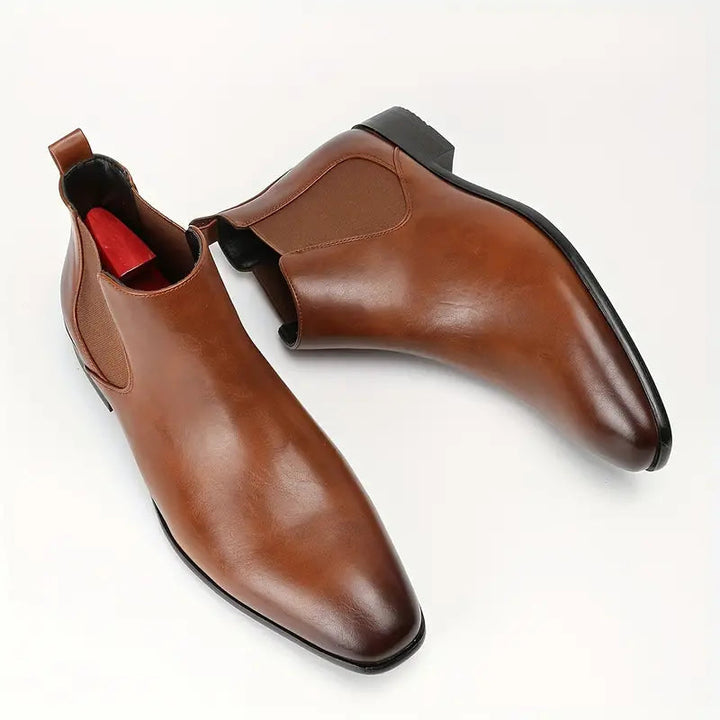 Pair of black leather Chelsea dress boots for men, featuring elastic side panels