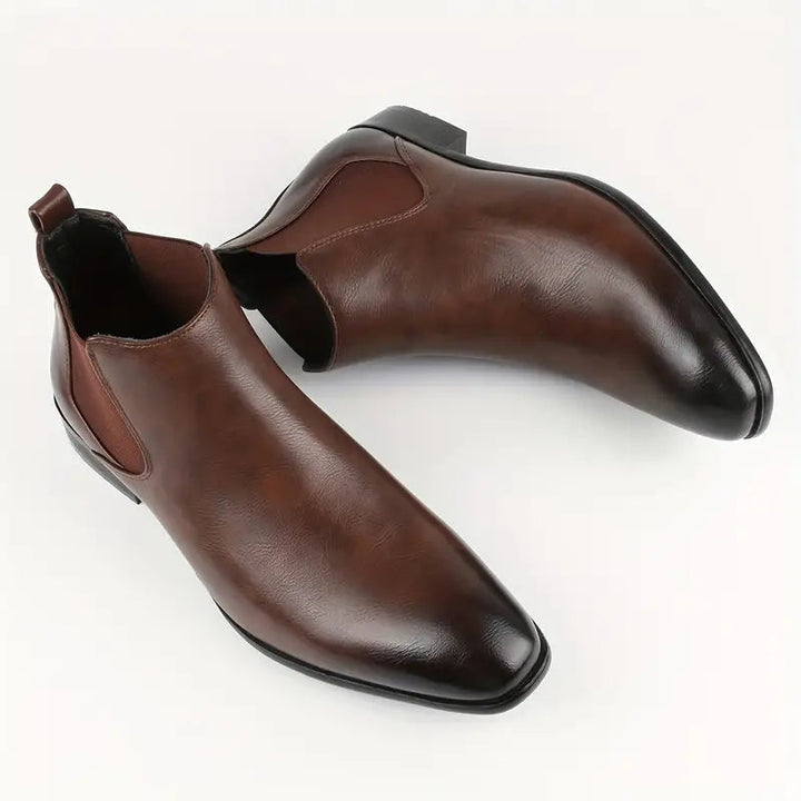 Full-length view of men's classic black leather Chelsea boots, suited for formal occasions