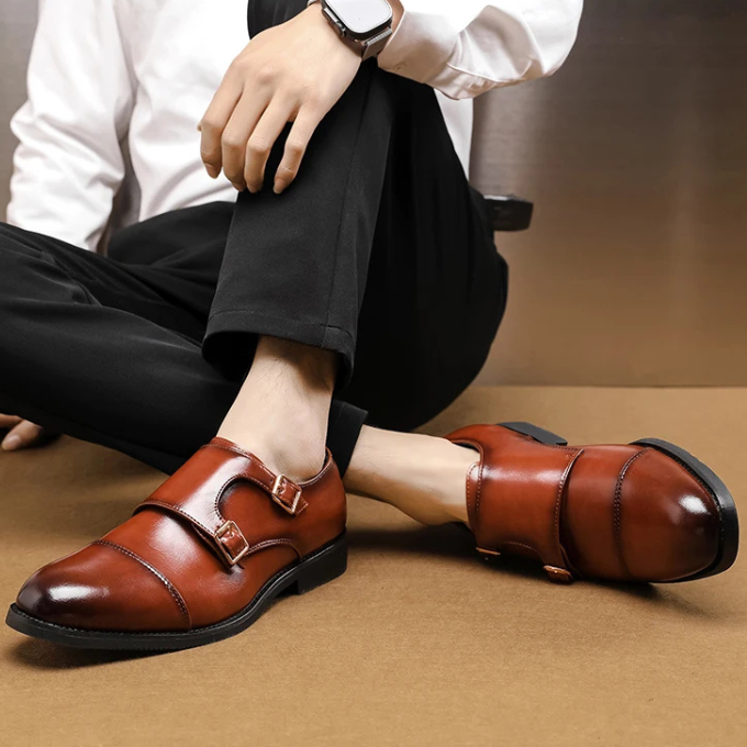 Angled shot of men's double monk strap shoes, displaying the luxurious leather and expert stitching details