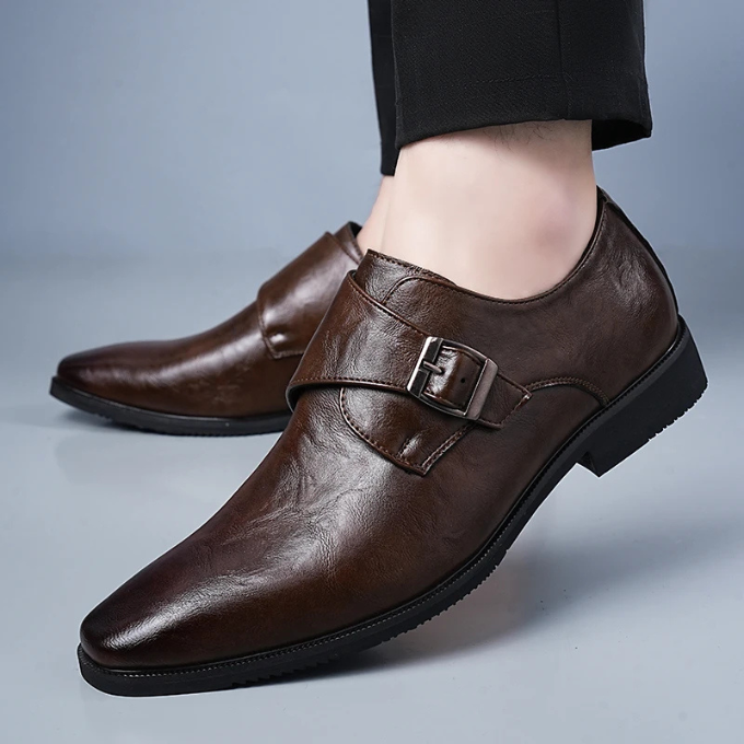 Close-up of a men's classic leather monk strap shoe, showcasing the detailed buckle and smooth leather texture. Formal footwear.