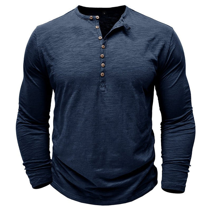 Classic men's long-sleeve henley shirt draped over a chair, emphasizing its casual and versatile nature