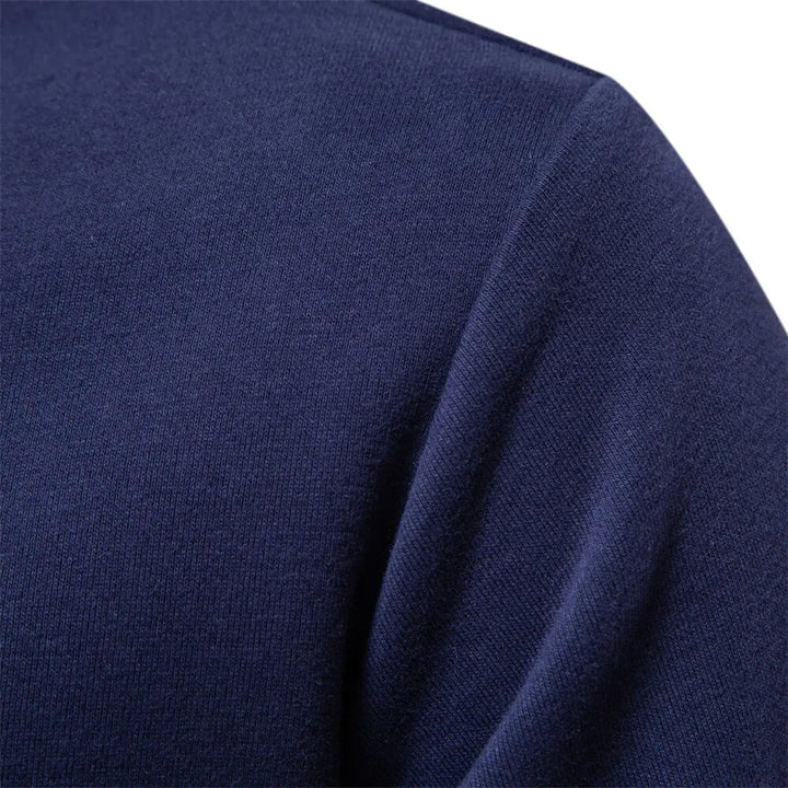 Side view of a man wearing a green classic fleece polo sweatshirt, showcasing relaxed fit.