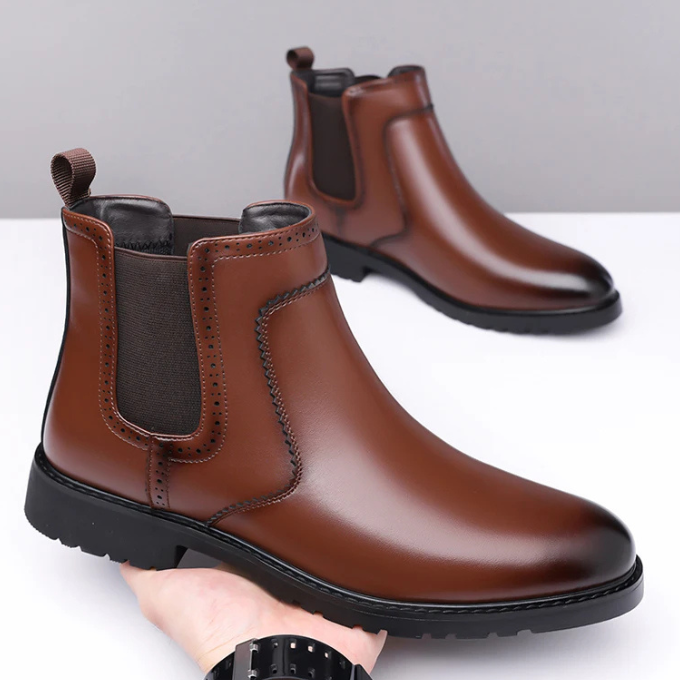A pair of Men's Classic Polished Chelsea Boots, black, standing on a light wooden floor, fashion