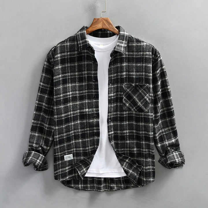Close-up of men's casual plaid flannel shirt fabric, showcasing the detailed checked pattern and brushed cotton texture