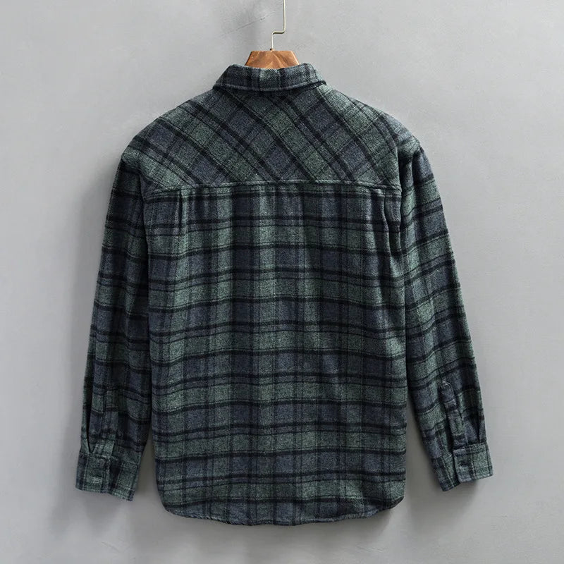 Stylish man wearing a long-sleeve men's flannel shirt in a blue and green plaid pattern, perfect for layering