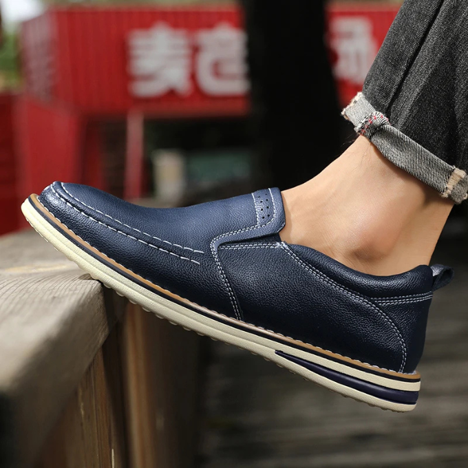 Top-down view of men's slip-on leather footwear, emphasizing the classic moc-toe loafer style.
