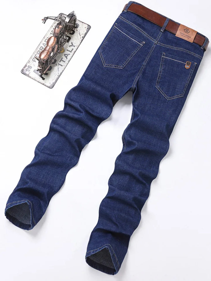 Detailed view of the stitching and hardware on men's premium cotton blue denim jeans, straight fit.