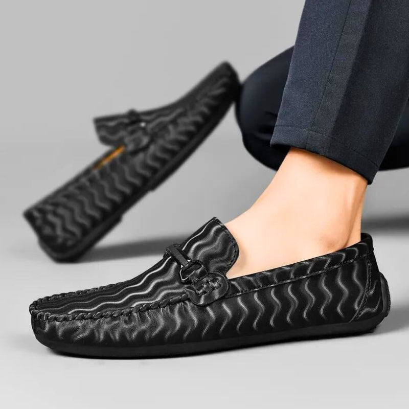 Close-up of men's black leather loafers, showcasing the sophisticated stitching and polished finish.