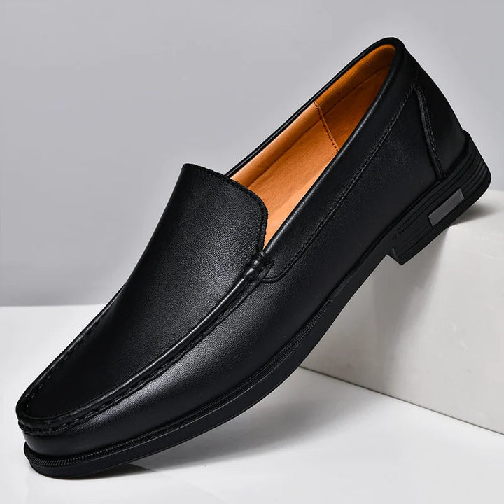 Pair of black men's leather slip-on loafers, versatile for formal events or everyday casual style.