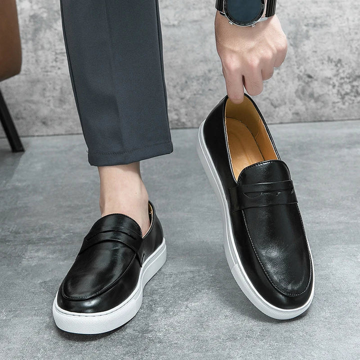 Top-down view of men's slip-on leather footwear, emphasizing the classic penny loafer style.