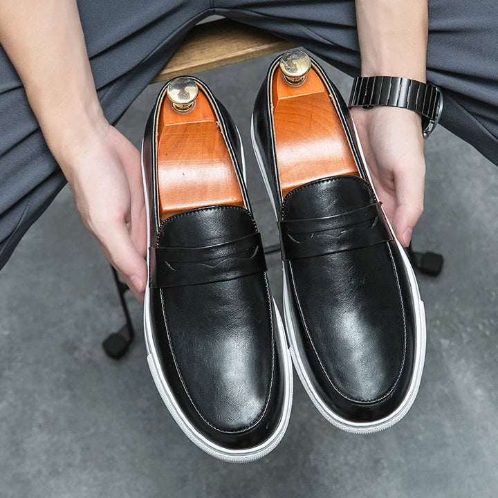 Men's leather loafers displayed on a wooden surface, highlighting quality and versatility.
