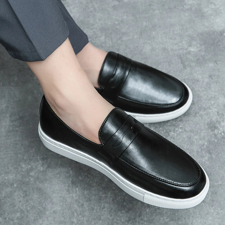 Texture shot of the rich, smooth leather on men's classic brown slip-on loafers.