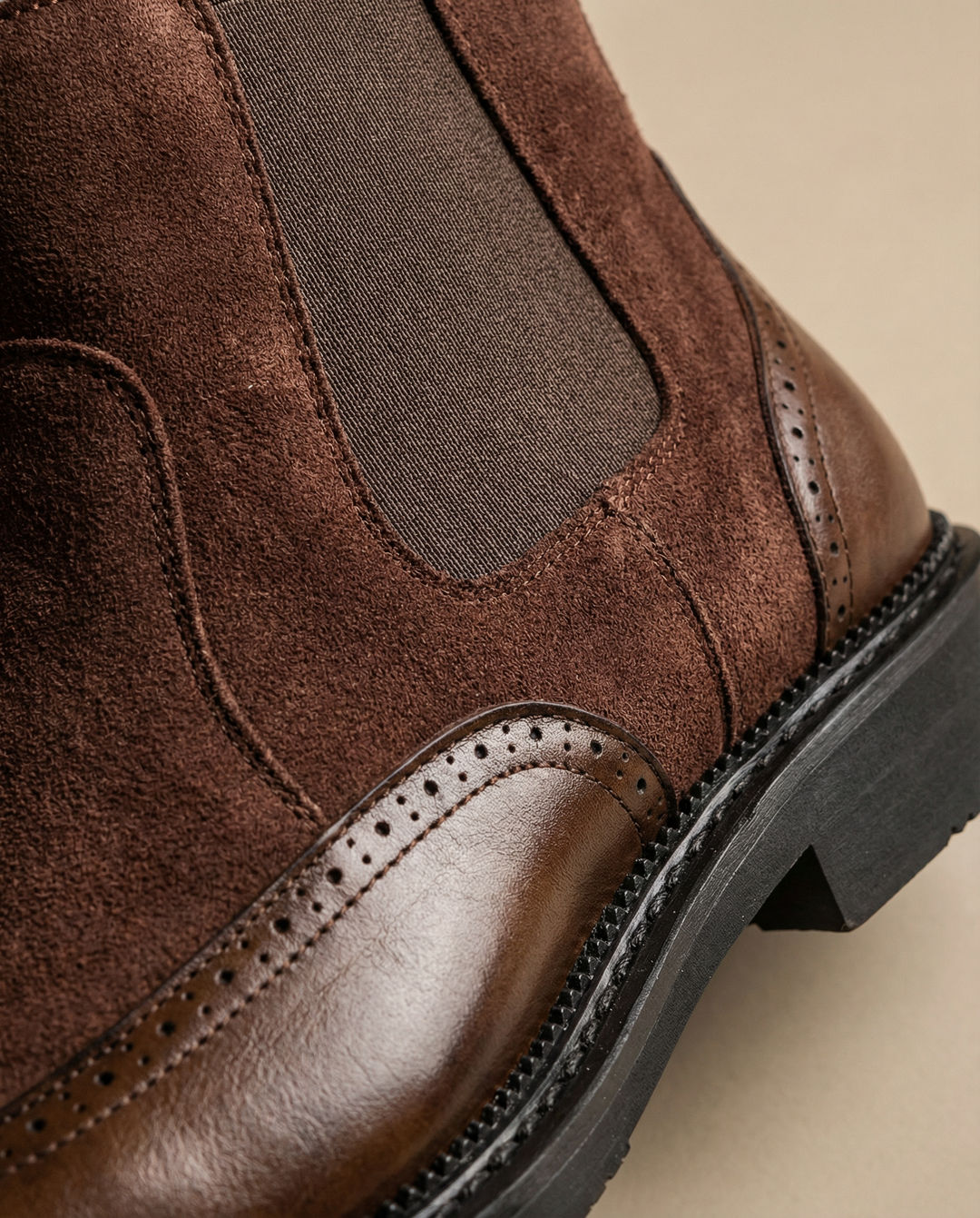 Close-up of the textured suede and elastic detail on a men's black Chelsea boot. High-quality leather boots.