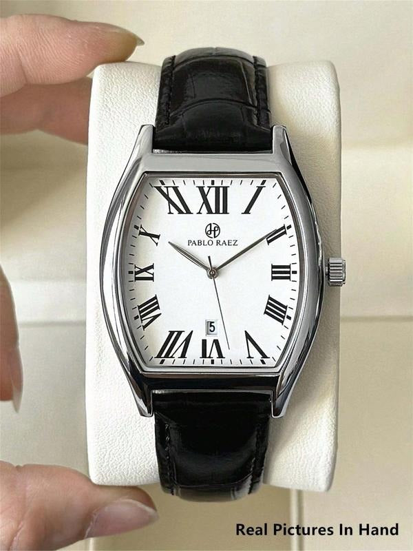 Close-up of men's tonneau dress watch, stainless steel case, white dial, black Roman numerals, leather strap