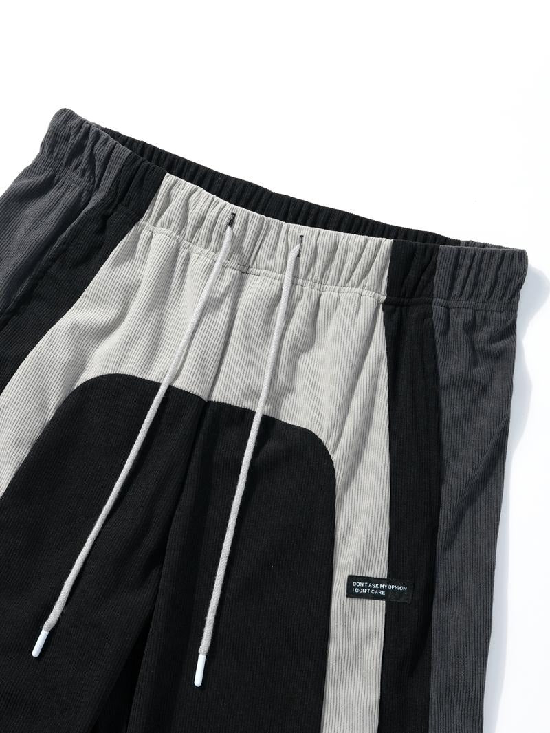 Men's corduroy track pants, color-block design, featuring elastic waist and tapered leg for streetwear look.