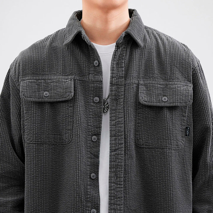 Close-up of men's corduroy button-up shirt in dark gray, showcasing fabric texture