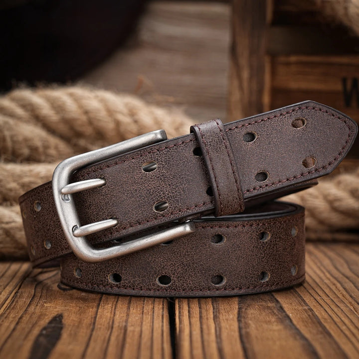 Styled men's distressed brown leather belt with perforated details, cinched around a denim pant waist.