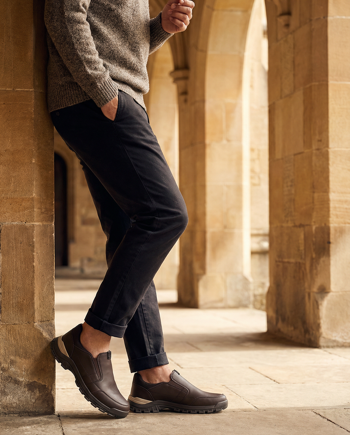 Stylish men's slip-on leather loafers by a workspace, showcasing versatile fashion.