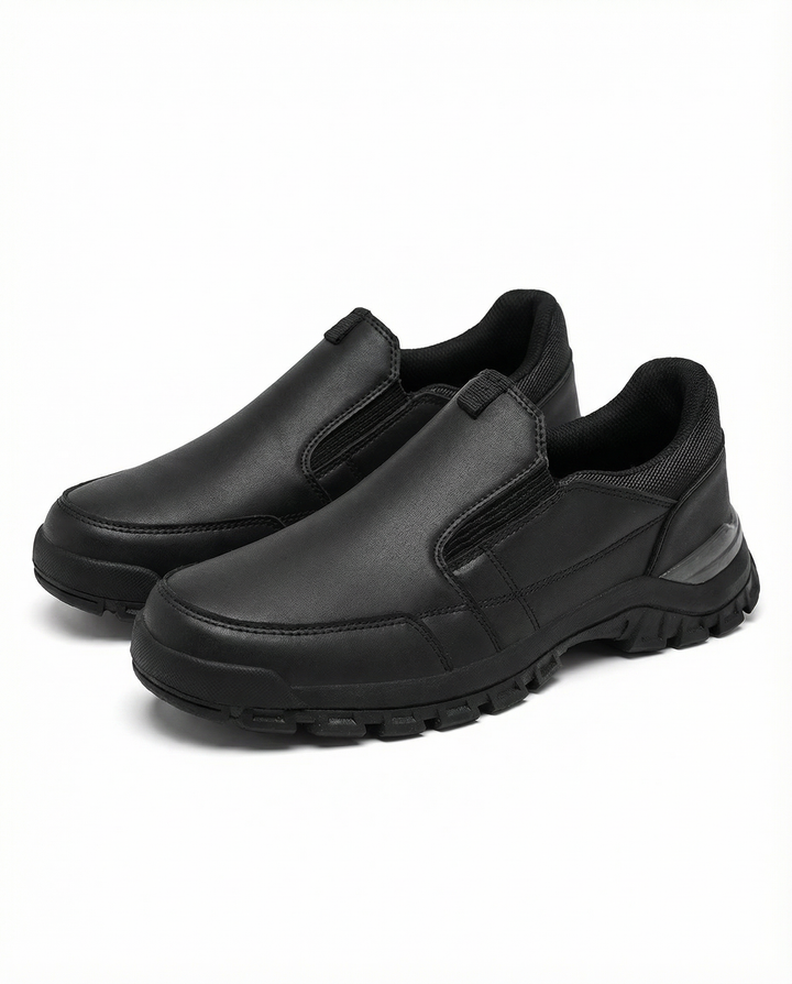Men's fashionable leather slip-on shoes on a wooden floor, emphasizing quality and ease.