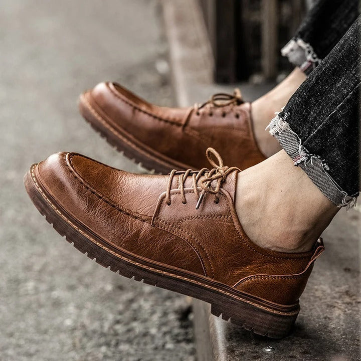 Close-up of a men's brown leather loafer, highlighting the durable stitching and quality material.